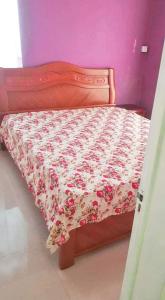 a bedroom with a bed with a floral bedspread at Charming villa in Flic en Flac with private pool in Flic-en-Flac