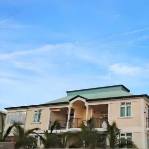 a building with palm trees in front of it at Charming villa in Flic en Flac with private pool in Flic-en-Flac