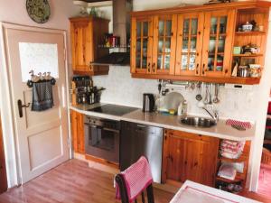 a kitchen with wooden cabinets and a sink at Alpenchalet in Murnau am Staffelsee +17 photos