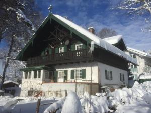 a house with a green roof in the snow at Alpenchalet in Murnau am Staffelsee