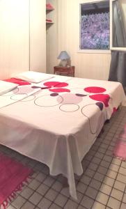 a bed with red roses on it in a room at Bungalow charmant proche de Bouillante avec climatisation. in Bouillante