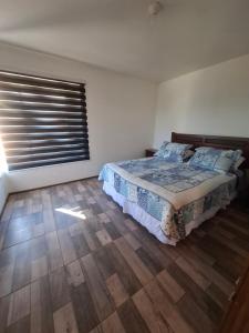 Un dormitorio con una cama y una ventana grande. en Cabañas don David, en Algarrobo