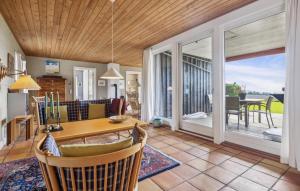 a living room with a table and chairs and a patio at 4 Bedroom Stunning Home In Karby in Karby