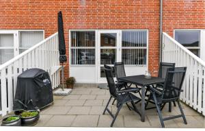 patio ze stołem i krzesłami oraz budynek w obiekcie Nice Home In Fanø With Wifi w mieście Fanø +20 zdjęć