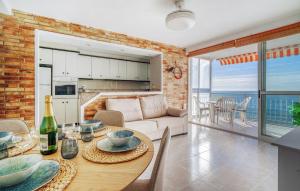 a kitchen and living room with a table and a couch at Nice Apartment In Oropesa Del Mar in Oropesa del Mar