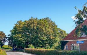 a large tree next to a brick building with a street light at Hoeve Aan De Waddenzee in Wierum +30 photos