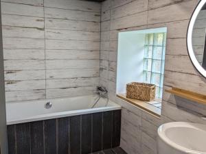 ein Badezimmer mit Badewanne und Waschbecken in der Unterkunft Maison rénovée avec jardin et espace détente proche Bergerac - FR-1-616-425 in Razac-de-Saussignac + 27 Fotos
