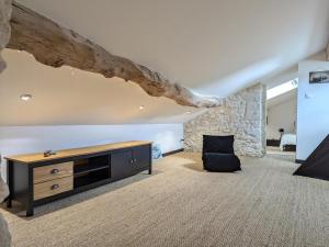 ein Wohnzimmer mit einer Holzkommode und einer Steinwand in der Unterkunft Maison rénovée avec jardin et espace détente proche Bergerac - FR-1-616-425 in Razac-de-Saussignac