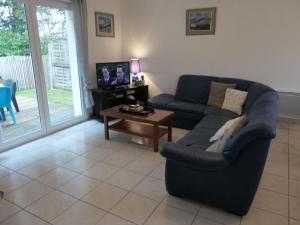 a living room with a blue couch and a table at Maison à Sarzeau, 3 chambres, plage et commerces proches, animaux admis, internet - FR-1-775-10 in Sarzeau