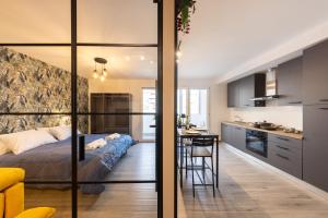 a bedroom with a bed and a kitchen with a table at Urban Chic Luxury Suite Apartments in Rome