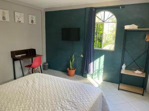 Un dormitorio con una cama y una ventana y una silla. en Habitación cerca del aeropuerto #1, en Tilapa