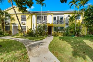 une maison jaune avec des palmiers et une allée dans l'établissement Sunshine Hideway, à Nassau