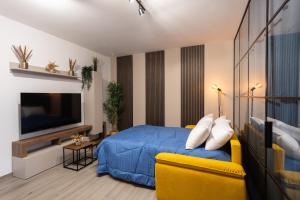 a bedroom with a blue bed and a yellow couch at Urban Chic Luxury Suite Apartments in Rome