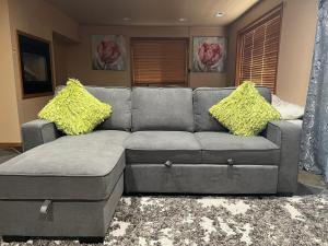 ボセルにある2 King Bed, Kitchenette, Game Area, Living Room, Office Room, Backyardのリビングルーム(黄色の枕付きのグレーのソファ付)