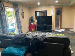 ボセルにある2 King Bed, Kitchenette, Game Area, Living Room, Office Room, Backyardのソファと薄型テレビのあるリビングルーム