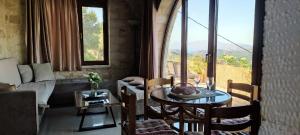 Una sala de estar con una mesa y sillas y una gran ventana. en Vasiliki's Residence Amazing View, en Kissamos 32 fotos más