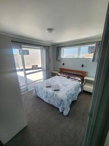 Un pat sau paturi într-o cameră la Raglan by the Sea - 2 Bedroom Apartment