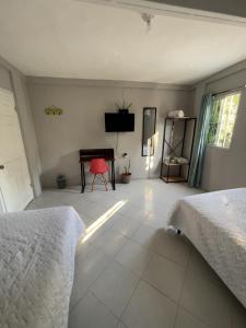 Un dormitorio con dos camas y un escritorio y un televisor. en Habitación cerca del aeropuerto #3, en La Paz 4 fotos más