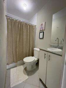 Un baño blanco con inodoro y lavabo. en Habitación cerca del aeropuerto #3, en La Paz