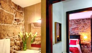 ein Badezimmer mit einer Steinmauer und einer Vase aus Blumen in der Unterkunft Comfortable house in Lindoso, stunning mountain view in Pedras de Moledo
