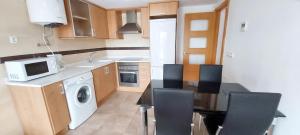 kuchnia ze stołem, krzesłami i kuchenką mikrofalową w obiekcie Cosy Apartment in Castellón with Shared Pool, 55 sqm w mieście San Rafael del Río