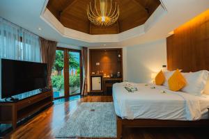 ein Schlafzimmer mit großem Bett und Flachbildfernseher in der Unterkunft Yotaka Khanom in Khanom