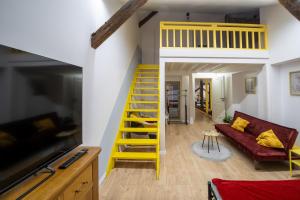a living room with a yellow ladder and a couch at Loft in 1902 Art-Nouveau Villa in Oradea
