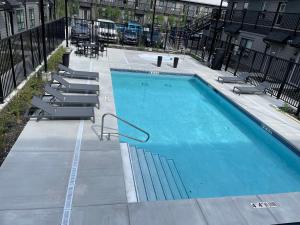 duży niebieski basen ze schodami obok budynku w obiekcie 2-in-1 Skyline MTN Retreat - Hot Tub - Pool - AC w mieście Canmore