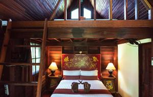 ein Schlafzimmer mit einem großen Holzbett mit zwei Lampen in der Unterkunft Leeloo Paradise in Khanom