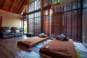 two beds in a room with a couch and windows at Khum Damnoen Resort in Ratchaburi +100 photos