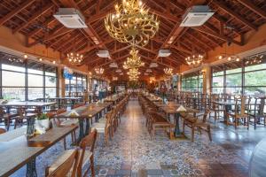 a dining room with tables and chairs and a chandelier at Khum Damnoen Resort in Ratchaburi
