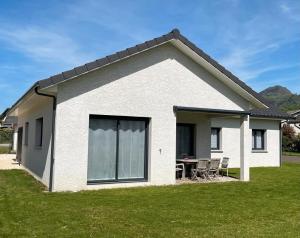 a small white house with a table and chairs at Les Chaudannes in La Croix-de la Rochette