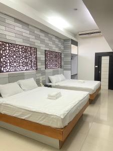 a bedroom with two beds with white sheets at Hi End Hotel Sriracha in Ban Fang Daeng