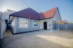 una casa con techo rojo y garaje en Zanzibar home Residence, en Zanzíbar