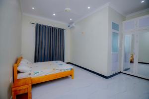 Un dormitorio con una cama en una habitación con ventana. en Zanzibar home Residence, en Zanzíbar