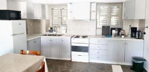 a kitchen with white cabinets and white appliances at House with sea view in Porto Heli, fireplace and garden in Porto Heli