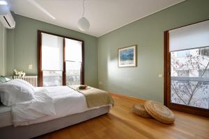 um quarto com uma cama grande e 2 janelas em KARYATIS LUXURY MAISONETTE by K&K em Atenas