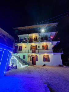 a large white building with lights on it at night at Pine View Kunal Home Inn Mashobra in Shimla
