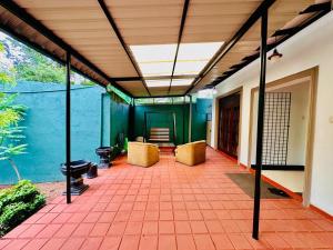 a patio with chairs and a large window at Himo Guest Inn in Dehiwala