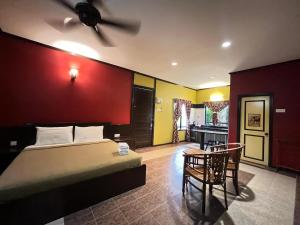 a bedroom with a bed and a table and chairs at INAP PULAI SENTOSA in Alor Setar