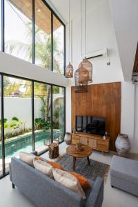a living room with a couch and a fireplace at Villa Casa Goya - Lofty Pool Villa Near The Beach in Vibrant Legian in Legian