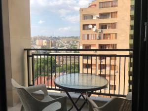 a table and chairs on a balcony with a view at Luxury - Premium Location 1 Bedroom Apartment in Yerevan