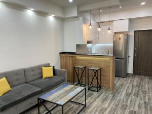 a living room with a couch and a kitchen at Luxury - Premium Location 1 Bedroom Apartment in Yerevan