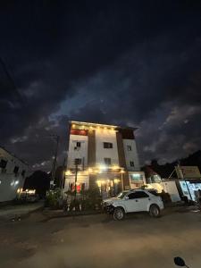 ヴァンヴィエンにあるRock Backpackers Central Hostelの夜間の建物前に駐車した白車