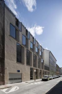 un grand bâtiment avec des voitures garées dans une rue dans l'établissement Modern old town studio - Balcony, Coffee, Wifi, à Vinohrady