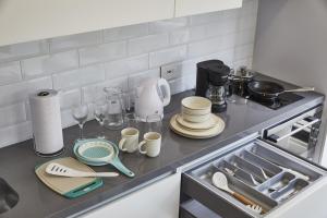 een aanrecht met kopjes en borden erop bij Luxury Living Across from El Virrey Park 301 in Bogota
