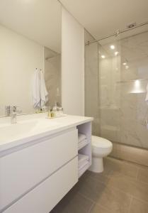 een witte badkamer met een wastafel en een toilet bij Luxury Living Across from El Virrey Park 301 in Bogota +1 foto