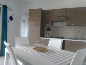 ムルタ・マリアにあるCasa Marina Mariaの白いテーブル(椅子付)と皿が備わるキッチンがあります。