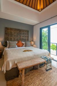 a bedroom with a large bed with a wooden headboard at Sister Suites in Seminyak +33 photos