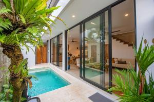 an indoor swimming pool in a house with plants at Sister Suites in Seminyak